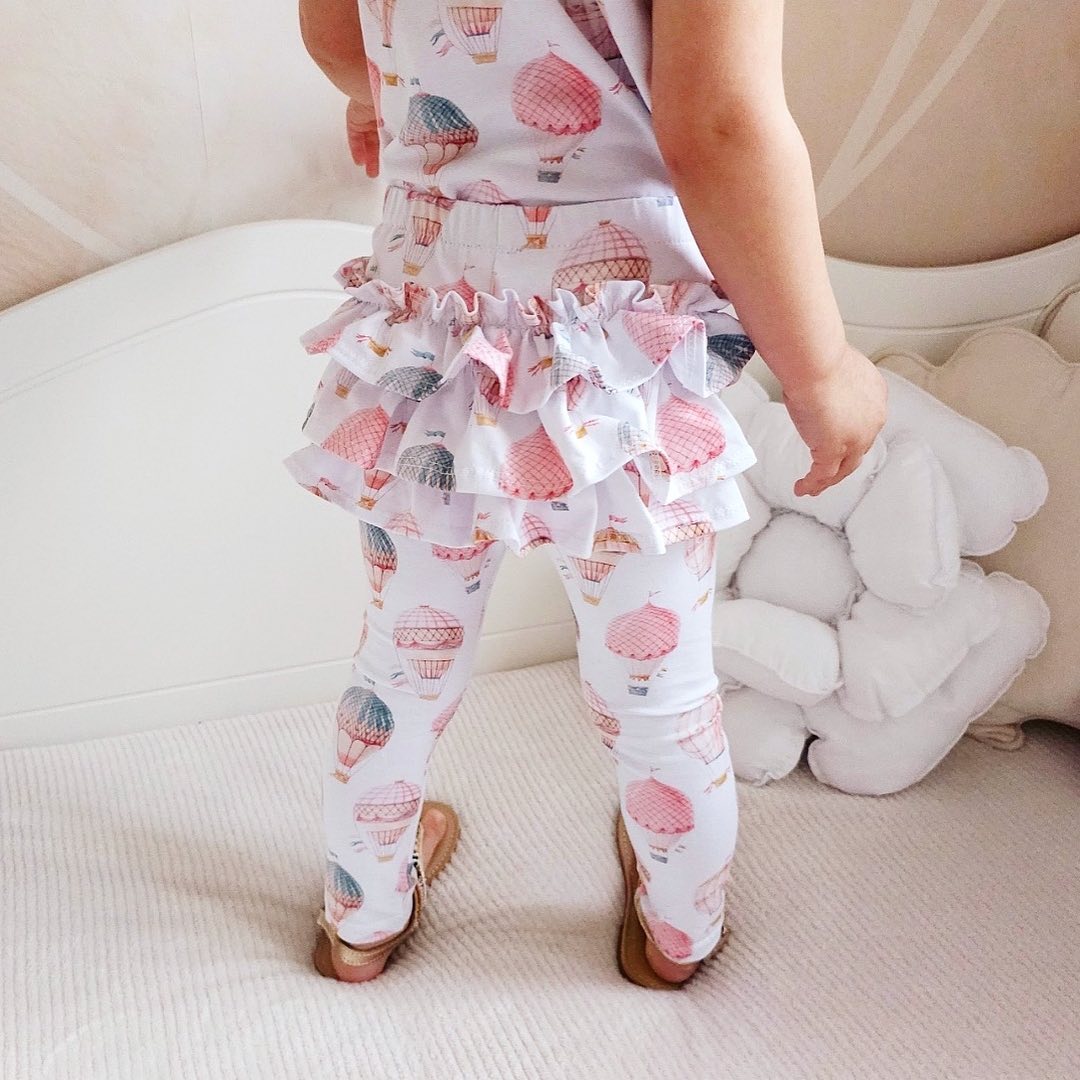 Achterkant van baby legging met ruches en luchtballonnenprint in zachte pasteltinten.