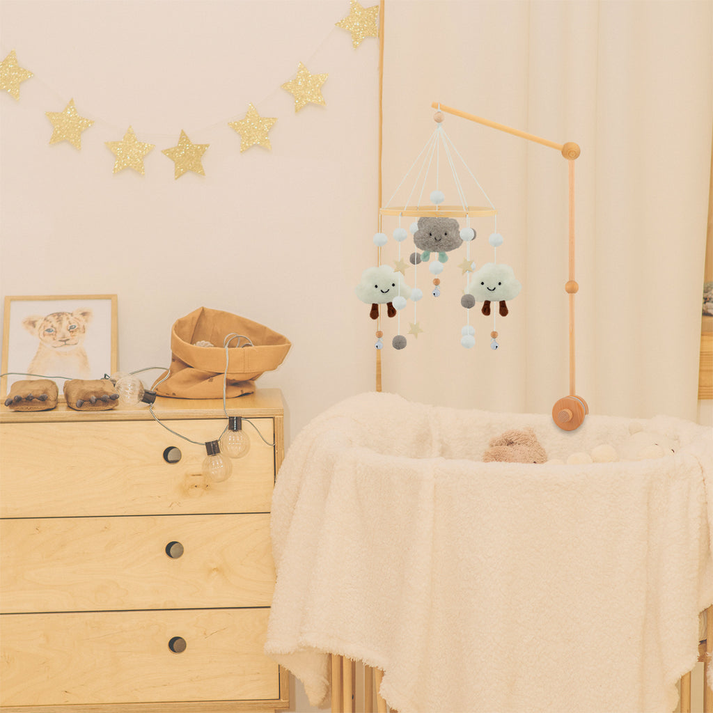 Babymobiel met zachte wolkjes boven een wieg in een rustige babykamer, decoratieve mobiel die zorgt voor een warme en kalmerende sfeer
