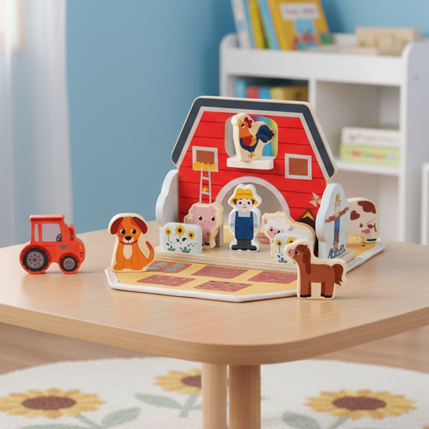Houten boerderij speelgoed opgesteld op tafel in kinderkamer, met dierenfiguren en tractor.