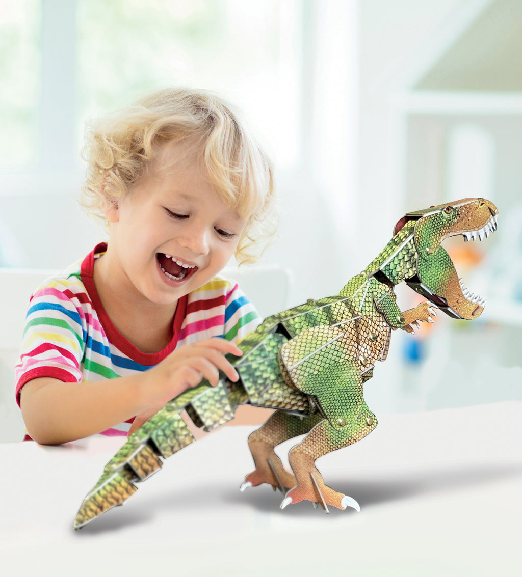 Klein kind dat speelt met een gemonteerde kartonnen T-Rex dinosaurus op tafel.
