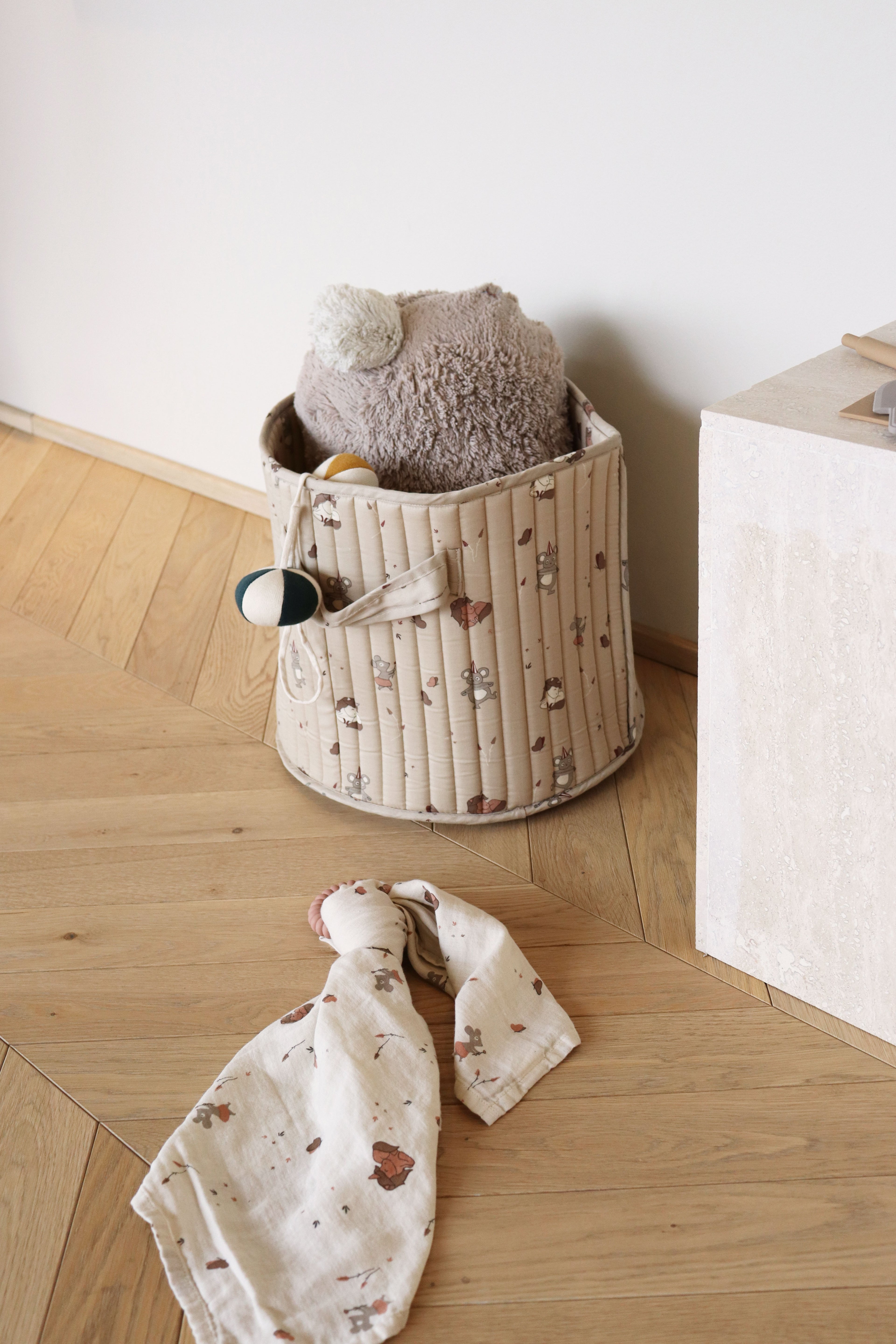 Gewatteerde stoffen opbergmand met unicornprint gebruikt in babykamer, decoratieve opbergzak voor speelgoed en textiel.