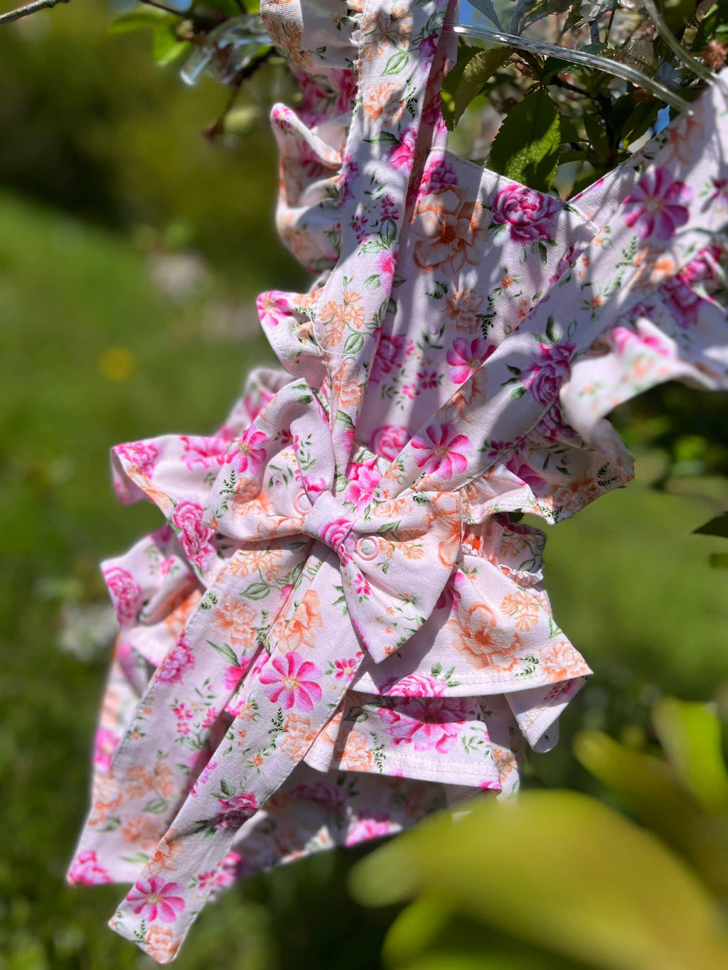 Zachtroze rompertje met bloemenprint achterkant met strik