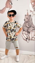 Jongen draagt een T-shirt met bos print en een groene short.