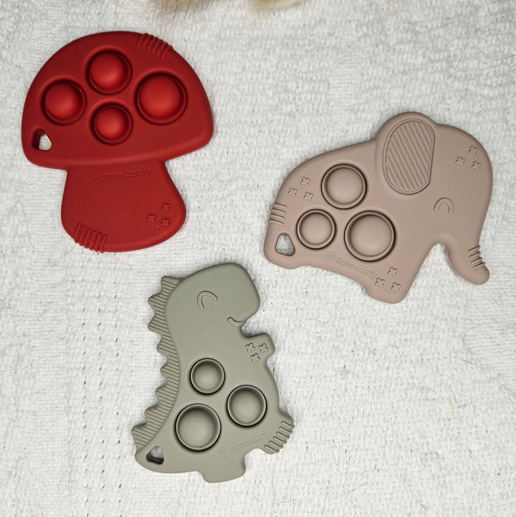 Drie siliconen bijtringen met pop-it in vormen van paddenstoel, olifant en dinosaurus