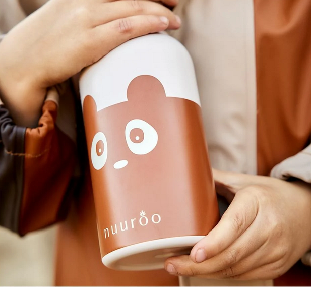 Kinder drinkfles met berenillustratie vastgehouden door kind