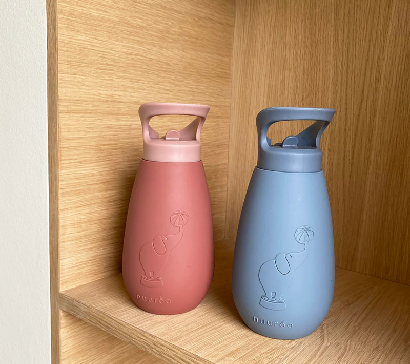 Baby drinkflessen met handvat in roze en blauw op houten plank